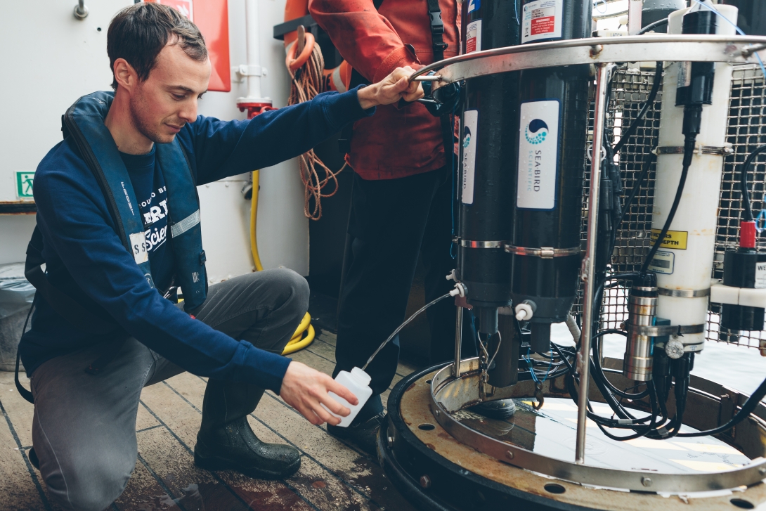 scientist taking water sample out of sampling device